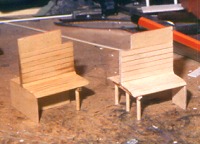 Foto: zwei hölzerne Sitzbänke mit Rückenlehnen für ein Personenwagen–Modell.
