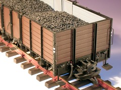 Modellfoto: Stirnwand und Pufferbohle. Hochbord–Güterwagen mit Kohleladung.