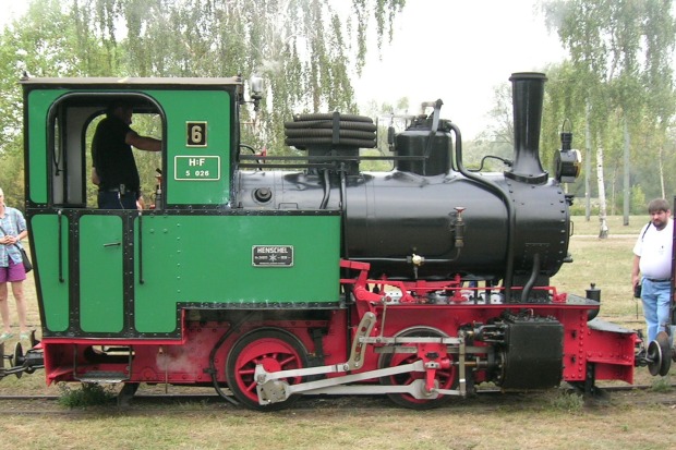 Zweiachsige Feldbahn–Dampflok Nummer 6 mit grünem Aufbau und rotem Fahrwerk.