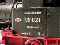Modellfoto: Metall–Schilder am Führerhaus einer Dampflok.