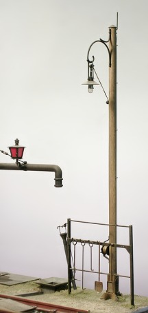 Modell: Bahnhofslampe bei einem Wasserkran mit einem Schürhakengestell.