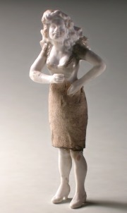 Die Figur einer jungen Frau mit wallendem Haar und knielangem Kleid.