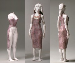 Einer Modellfigur wird ein Kleid aus bedrucktem Paper (Karomuster) angemessen.