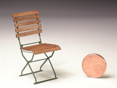 Klappbares Gartenstuhl–Modell aus Echtholzleisten und geätztem Metall, daneben eine stehende Münze als Größenvergleich.