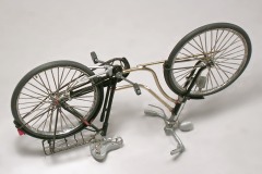 Das Fahrradmodell steht überkopf, in der Mitte die neuen Rahmenteile aus Messing.