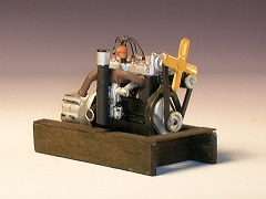 Modellfoto: Kraftfahrzeug–Motor auf einer Halterung aus Holz.
