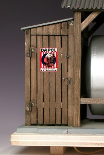 Modellfoto: Schuppen von der Seite mit geschlossener Tür, darauf eine Werbetafel.