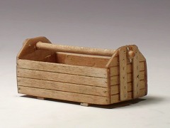 Modellfoto: Werkzeugkiste aus Holz mit oben liegendem Griff.