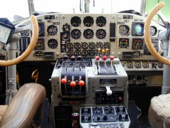 Blick in die Pilotenkanzel mit Doppelsteuerung und vielen Instrumenten.
