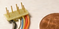 NEM–Stecker: Platine mit sieben Kontaktstiften oben und Kabeln unten.