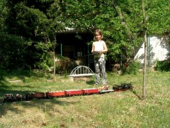 Ein Mädchen steuert eine Gartenbahn–Lok mit Funkfernsteuerung.