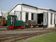 Eine Deutz–Diesellok bringt mit dem Flachwagen Biertische zur Wagenhalle.