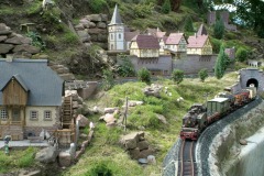 Gartenbahn-Motiv mit einer Stadt aus Fachwerkhäusern und einer Wassermühle.