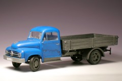 Modellfoto: kleiner Lastwagen mit grauer Prische und blauem Führerhaus.