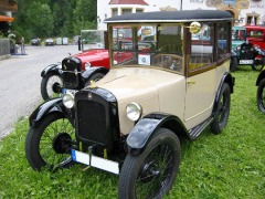 Kleinwagen mit festem Dach, die Karosserie ist beige, die Kotflügel sind schwarz.