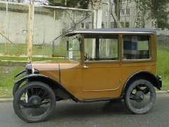 Hellbrauner Kleinwagen mit festem Dach, zwei Türen und vier Sitzplätzen von der Seite gesehen.