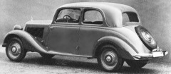 Schwarzweiß–Foto: zweitüriges, geschlossenes Auto von links.