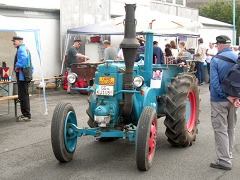 Lanz Bulldog–Traktor mit roten Felgen, schräg von vorne gesehen.