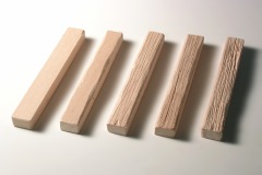 Fünf Holzschwellen in verschiedenen Bearbeitungs–Zuständen.