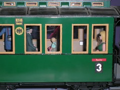 Foto: Grüner Personenwagen mit drei Fensterpaaren auf jeder Seite, jeweils mit hölzernen Rahmen.