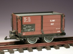 Modellfoto: kleiner, offener Güterwagen mit hohen, braunen Bordwänden und abklappbaren Seitenwänden.