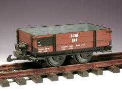 Modellfoto: kleiner, offener Güterwagen mit niedrigen, braunen Bordwänden.