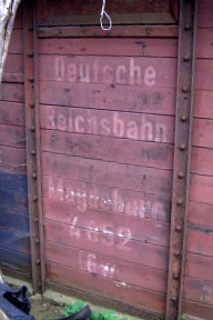 Reichsbahn–Beschriftung am stark verwitterten Wagenkasten eines gedeckten Güterwagens.