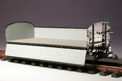 Modellfoto: offener Güterwagen mit senkrecht abgeklappten Seitenwänden.
