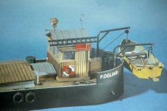 Das Heck eines kleinen Frachtschiffs mit einem Rettungsboot hinten.