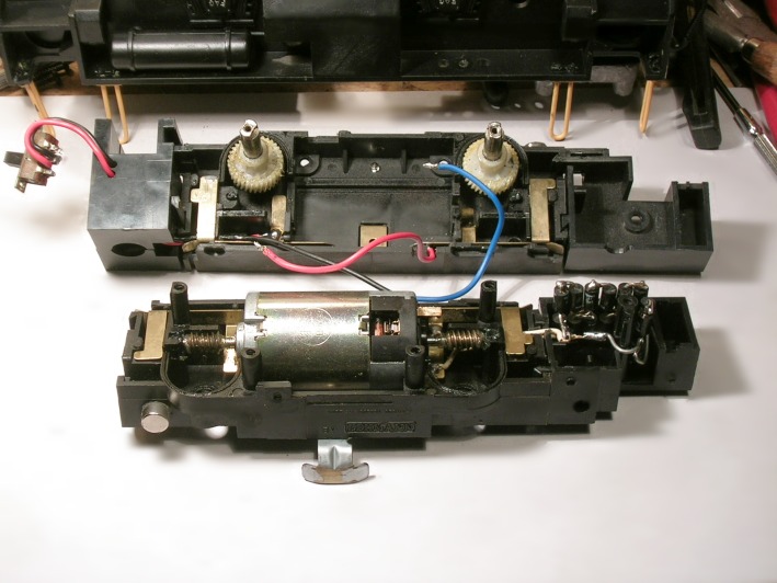Blick auf die getrennten Halbschalen eines Lokomotiv–Antriebs mit Zahnrädern und Motor.