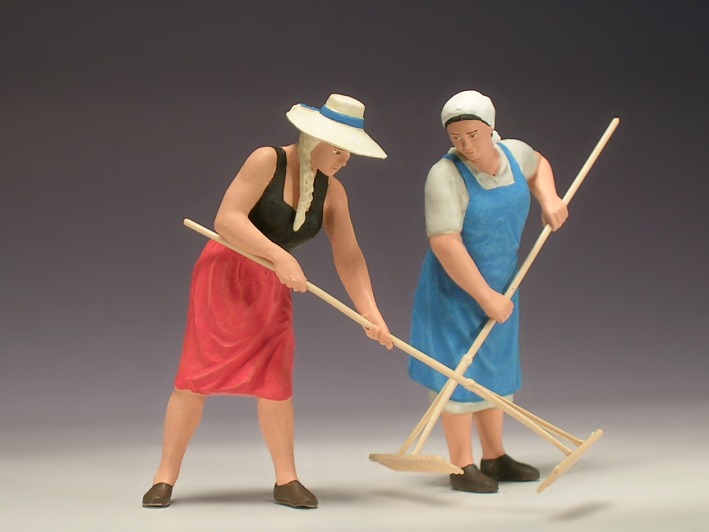Zwei Frauen bei der Heuernte, eine junge mit Hut und eine ältere mit Kopftuch.