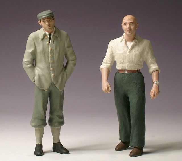 Zwei Männerfiguren, der eine mit Knickerbockern, der andere mit weiten Hosen.