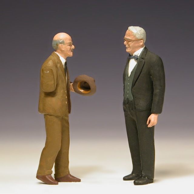 Modellfiguren: zwei ältere Herren stehen einander gegenüber.