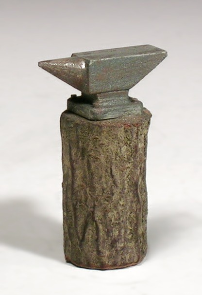 Modellfoto: Metallisch glänzender Amboss auf einem Holzstrunk.