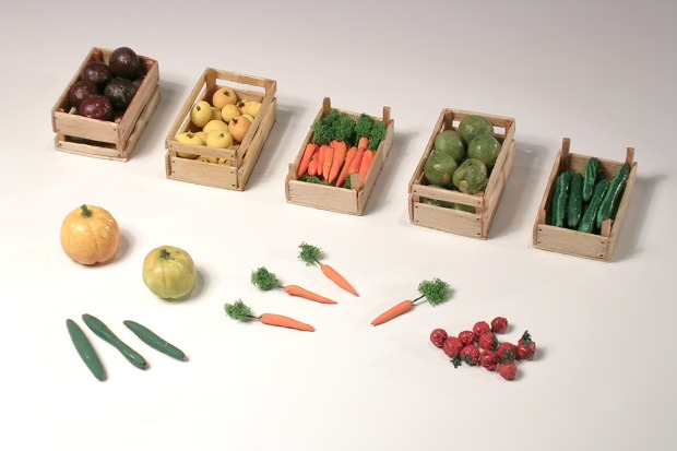 Fünf Kisten mit Obst und Gemüse, davor zwei Kürbisse, Möhren, Salatgurken und Tomaten.