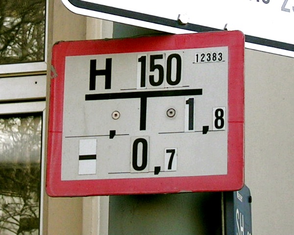 Foto: Schild für einen Hydranten mit 150 Millimeter Nennweite an einem grünen Straßenlaternen–Mast.