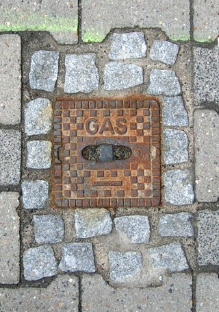 Foto: Kleiner, quadratischer Deckel mit Aufschrift „GAS” von oben gesehen.
