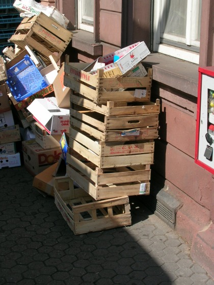 Vor dem Laden eines Obst– und Gemüsehändlers zur Entsorgung gestapelte, leere Obst– und Gemüsesteigen.