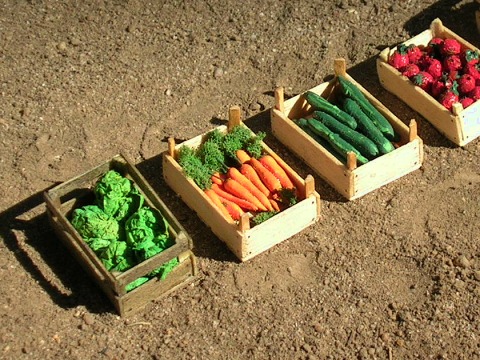 Modelle, links nach rechts: Salatköpfe, Möhren, Gurken und Tomaten in Kisten.