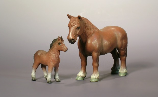 Zwei braune Tierfiguren, ein Fohlen und ein Pferd.