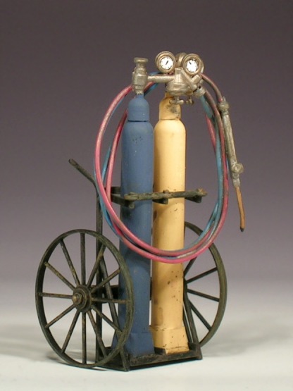 Schweißgerät von Pola: Gasflaschen mit Armaturen und Schläuchen auf einem Wagen.