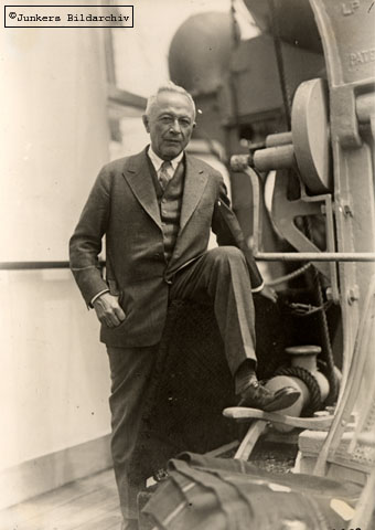 Hugo Junkers steht hinter einer Liege auf einem Schiff und blickt in die Kamera.