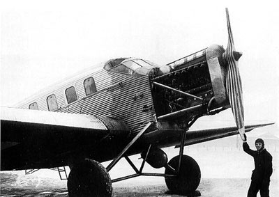Frontpartie der Junkers F 24. Ein Mann stützt sich am Propellerblatt einer einmotorigen Junkers F 24 ab.