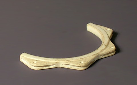 Modellfoto: Die Hälfte eines ringförmigen Drehteils mit doppelten Haltern an der Außenseite.