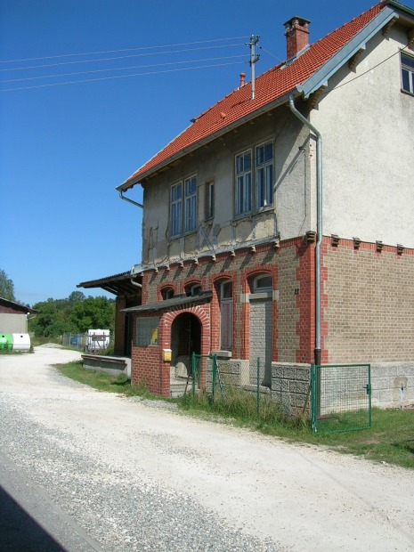 Zweigeschossiges Bahnhofsgebäude mit Ladeboden und Güterschuppen, Straßenseite.