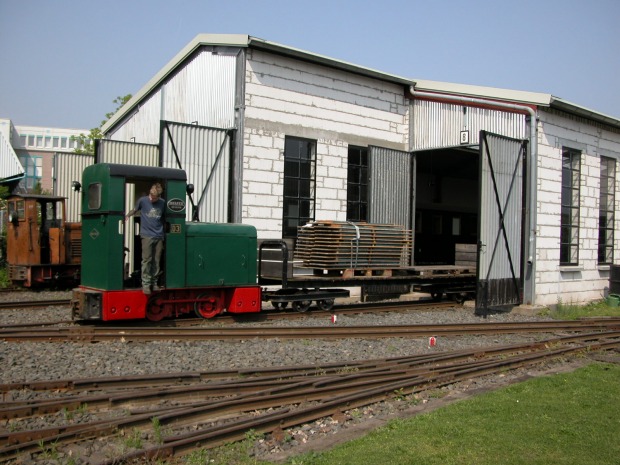 Eine Deutz–Diesellok bringt mit einem Flachwagen Biertische zur Wagenhalle.