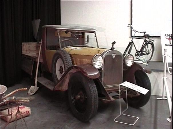 Foto: Sand–farbener Adler–Personenkraftwagen mit Pritschen–Aufbau auf einer Ausstellung.