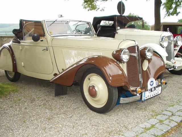 Foto: ockerfarbenes, zweitüriges Cabrio mit hellbraunen Kotflügeln.