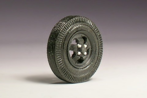 Rad mit Reifen, die Felge hat fünf Löcher und Mutternimitationen aus Polystyrol.