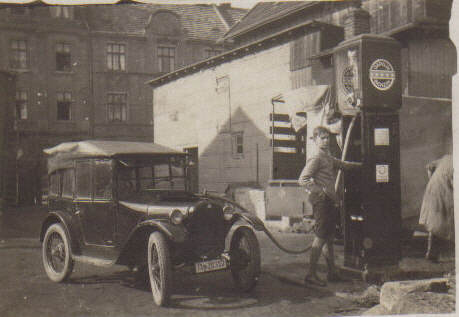 Klein–Limousine (DIXI) an der Tankstelle, ein Junge steht an der Zapfsäule.